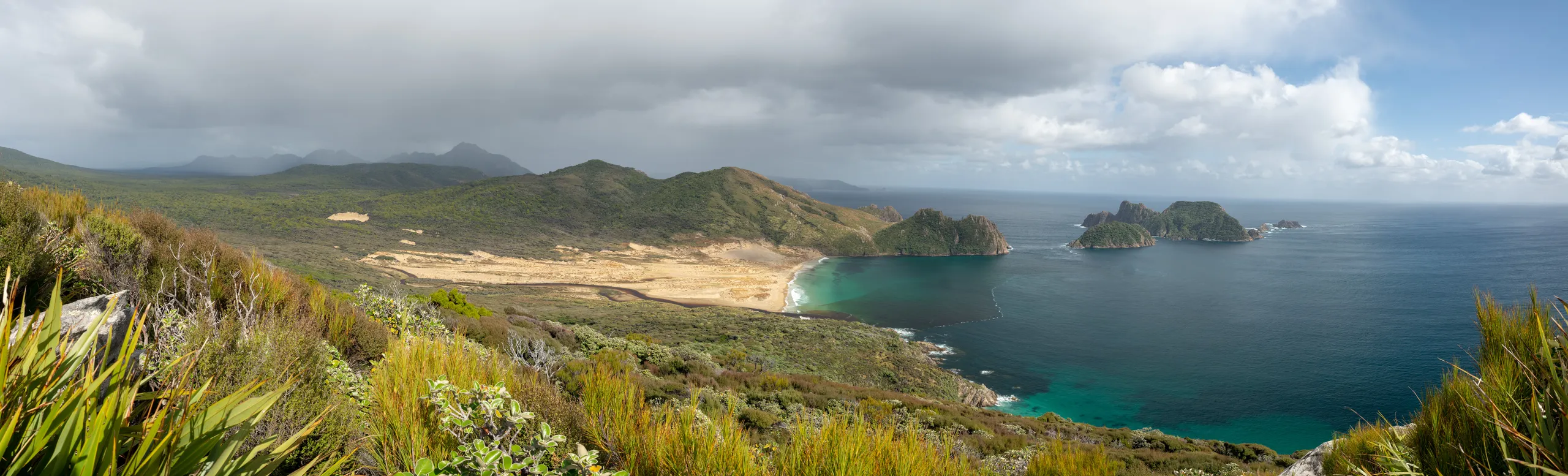 Looking west to East Ruggedy Beach and the Rugged Islands with the Ruggedy Mountains visible in the distance along with approaching rain